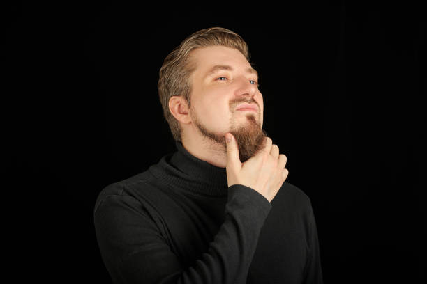 istock Thoughtful bearded man, half profile portrait, black background 1333586803