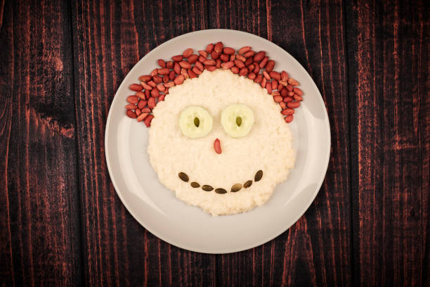 Food smile face. Funny eating concept with rice, nuts and cucumbers.