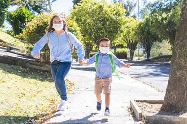 istock A boy and a girl with a mask running down a path back to school 1333587003