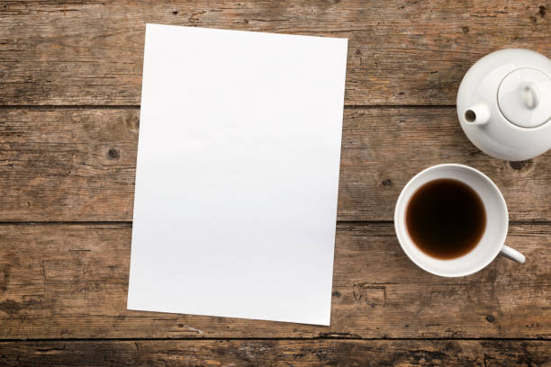 istock Blank paper, tea pot and tea cup on rustic wooden background, high angle view 1333588855