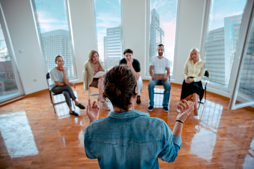 Rear view of Man Speaker talking to his colleagues on casual business meeteng