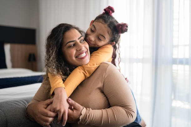 felice madre e figlia condividendo momento legame a casa - house kissing women residential structure foto e immagini stock