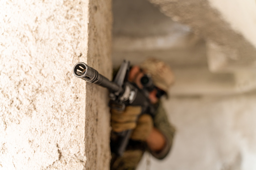 Horizontal photo of soldier using automatic weapon