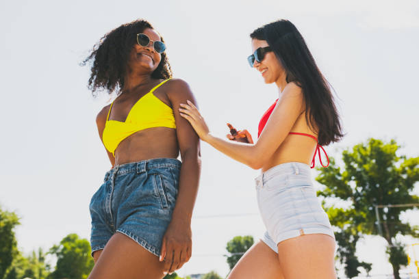 istock Two young beautiful women sunbathing on the beach on bright summer day 1333594067
