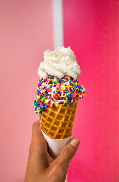 istock Colorful ice cream cone with sprinkles and whipped cream 1333594327
