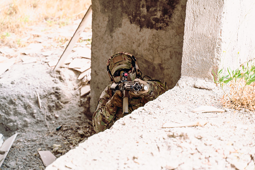 Horizontal photo of soldier using automatic weapon