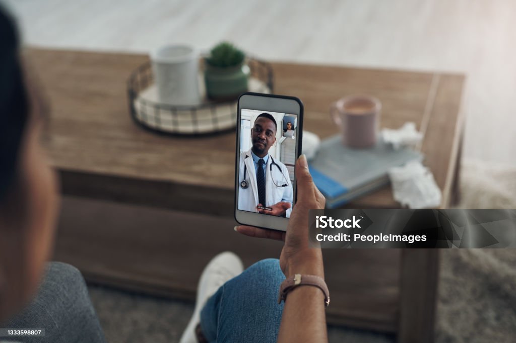 Shot of an unrecognizable person on a videocall with a doctor It's not anything to be worried about Telemedicine Stock Photo