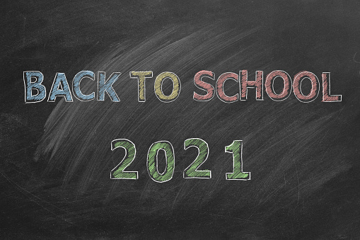Hand drawn Back to School 2021 text on blackboard.