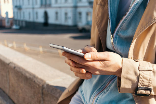 istock Close-up young woman wearing beige coat typing 1333602911