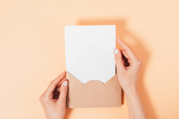 vista aérea mãos femininas segurando envelope de papel marrom aberto - stationary sheet template paper - fotografias e filmes do acervo