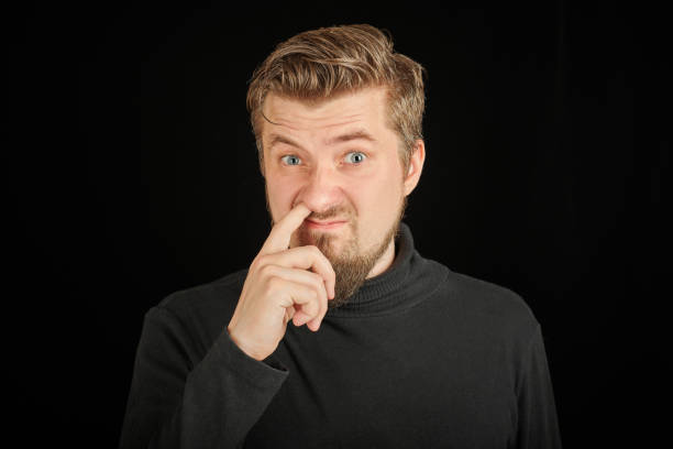 istock Funny bearded man picking his nose, black background 1333608554