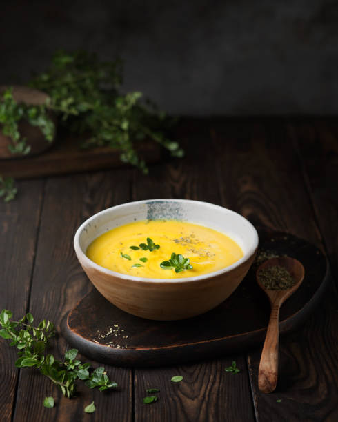 Vegetable puree soup on a dark wooden background. Pumpkin cream soup with thyme. Serving an autumn dish. Vegetarian food. Vegan cuisine. Dark style DELICIOUS LUNCH pumpkin soup photos stock pictures, royalty-free photos & images