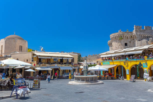 sightseeing place at hot summer sunshine afternoon. tourists at the intersection aristotle str""socrates str- hippocrates square at the rhodes old town of rhodes, greece - editorial built structure fountain town square imagens e fotografias de stock