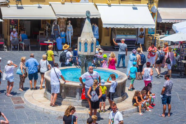 sightseeing place at hot summer sunshine afternoon. tourists at the intersection aristotle str""socrates str- hippocrates square at the rhodes old town of rhodes, greece - editorial built structure fountain town square imagens e fotografias de stock