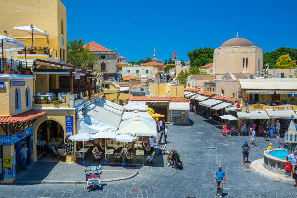 sightseeing place at hot summer sunshine afternoon. tourists at the intersection aristotle str""socrates str- hippocrates square at the rhodes old town of rhodes, greece - editorial built structure fountain town square imagens e fotografias de stock