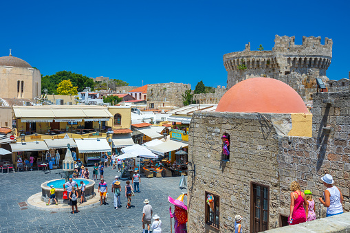 Rhodes, Greece - June 29, 2021: sightseeing place at hot summer sunshine afternoon. Tourists at the intersection Aristotle Str\