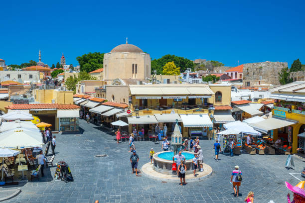 sightseeing place at hot summer sunshine afternoon. tourists at the intersection aristotle str""socrates str- hippocrates square at the rhodes old town of rhodes, greece - editorial built structure fountain town square imagens e fotografias de stock