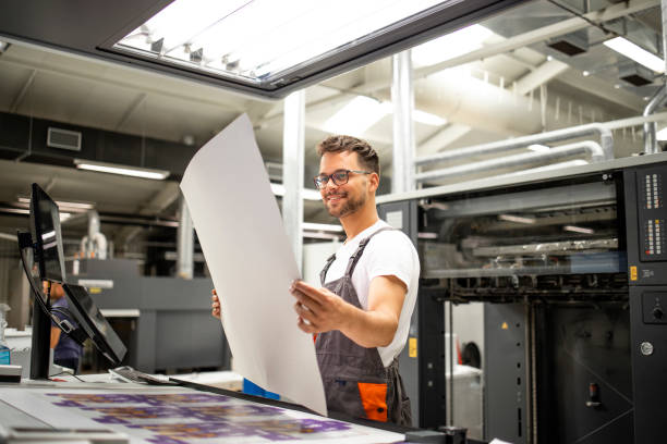 istock Print shop worker checking quality of imprint and controlling printing process. 1333611431