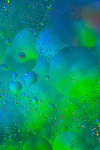 Close up image of mixed oil with water on colorful gradient background