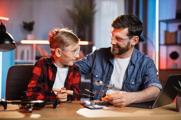 istock Father with son fixing display card from laptop 1333613374