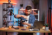 Man using various tools for repairing quadcopter at home