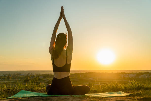 istock Young woman practicing yoga with sunset in nature 1333616638