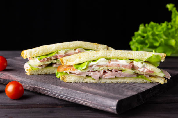 istock Triangular sandwiches with toast, lettuce and vegetables on a dark background. Healthy and delicious breakfast or lunch. 1333618443