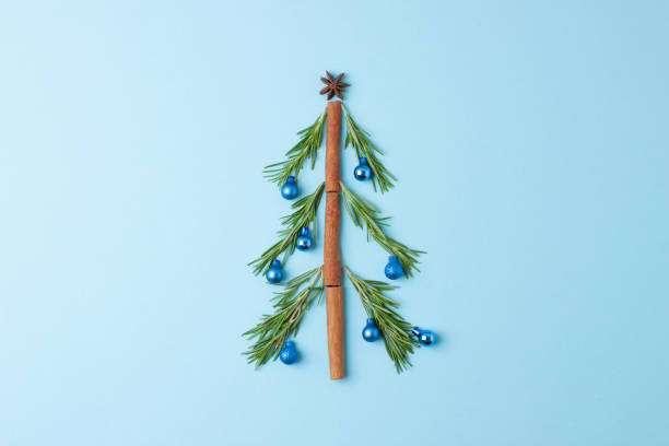 istock Christmas tree shape made with rosemary and balls blue background. Flat lay, copy space 1333621293