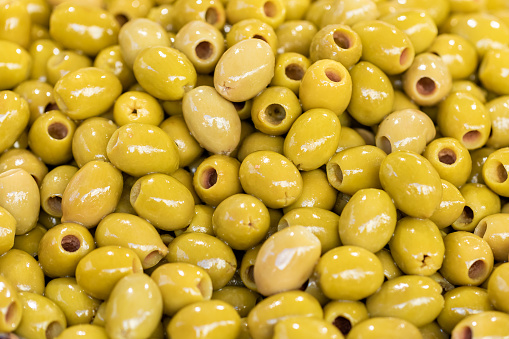 Green pitted olives close-up. Food backgrounds. Background of green olives. Organic food. Top view. Macro