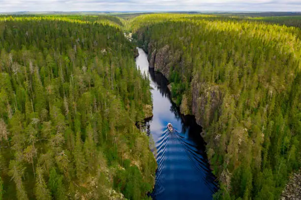 Photo of Aerial view of a boat, canyon lake and forest in Julma-Ölkky, Hossa National Park, Finland