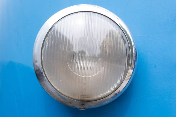 Closeup of a vintage train headlight with a chrome trim on blue surface stock photo