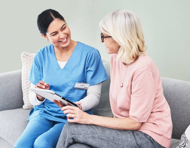 istock Shot of a female nurse using a digital tablet while sitting with her patient 1333627756