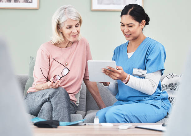 istock Shot of a female nurse using a digital tablet while sitting with her patient 1333627777