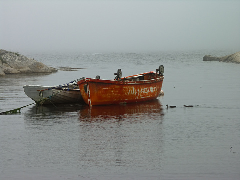 Two fishing boats in calm harbor of Peggy's Cove, Nova Scotia Canada.
