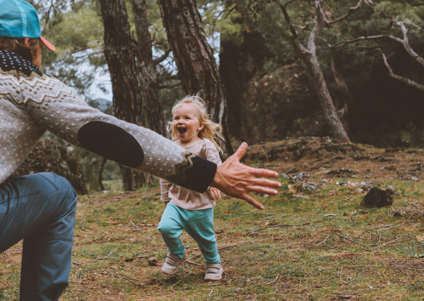 laughing child running to father family walking together in forest lifestyle positive happy emotions daughter with dad - nordic running imagens e fotografias de stock