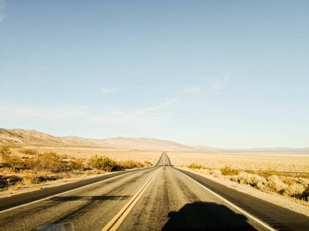 istock Car shadow on a lonely road in California 1333633793