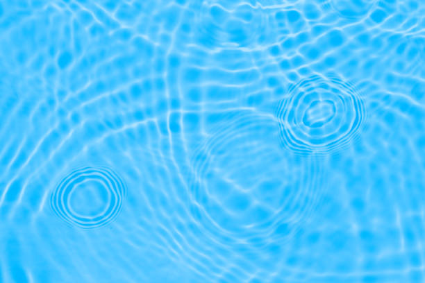 istock Surface of light deep blue transparent swimming pool water texture with circles on the water. Trendy abstract nature background. Water waves in sun light reflections. 1333634955