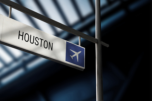Airport departure for Houston information board sign. Close-up. Roof construction in the background. Blue color. Horizontal orientation.