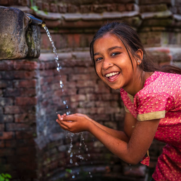 jeune fille népalaise buvant de la fontaine de la ville sur durbar square - durbar square photos et images de collection