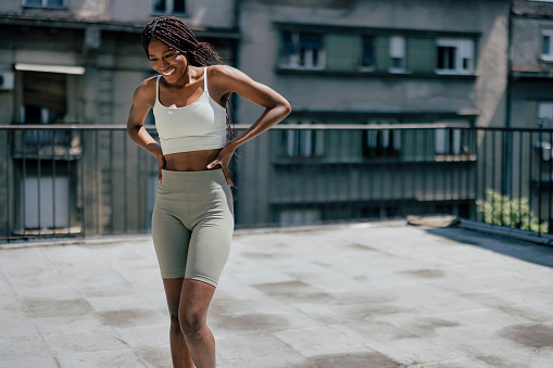 Portrait of young smiling African American woman having pause during fitness