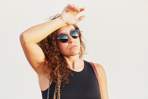 Young hispanic woman with sunglasses roast over white background