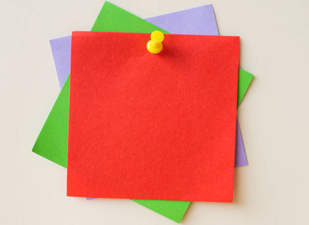 istock Colorful Paper Notes Stacked Together And Pinned On The Wall. Different Colored Sheets Of Note Attached On A Plain Wallpaper With A Pin. 1333654763