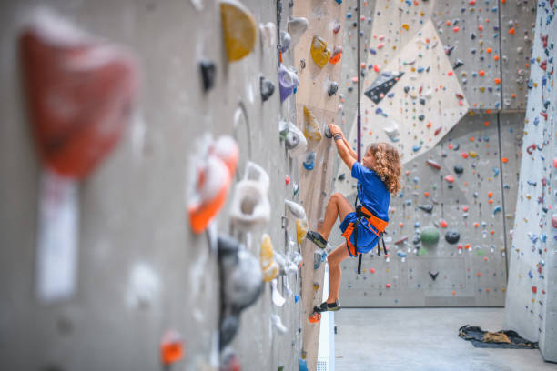 little girl climbing a rock wall outdoor in public park. High quality photo