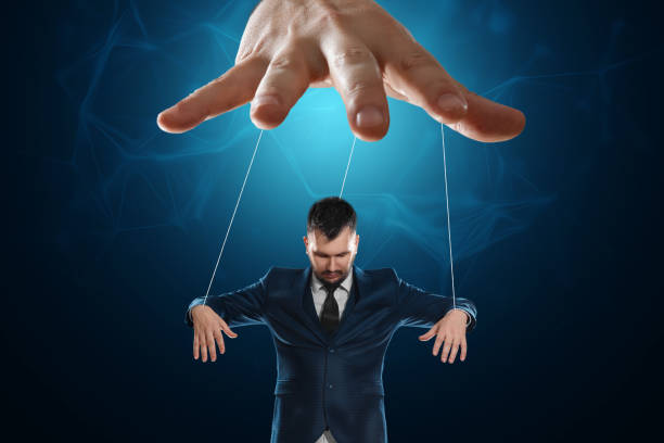 istock Male hand, puppeteer controls the puppet puppet with strings. A doll on her knees. The concept of world conspiracy, world government, manipulation, control. 1333661382
