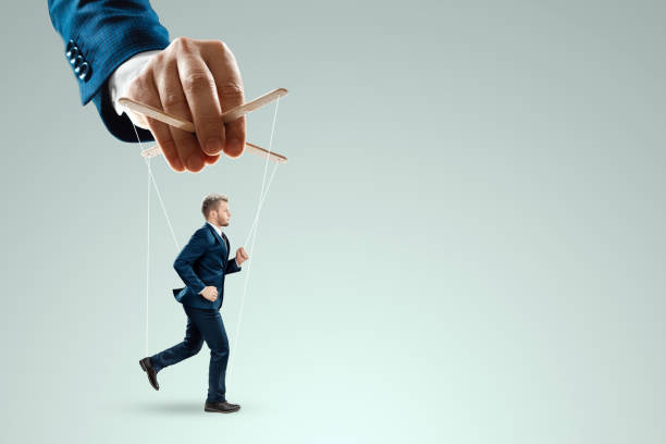 istock Male hand, puppeteer controls the puppet puppet with strings. A doll on her knees. The concept of world conspiracy, world government, manipulation, control. 1333661390