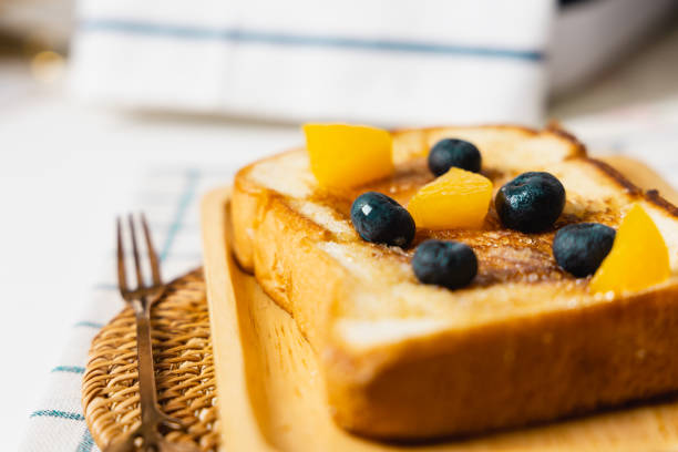 french toast with honey syrup and blueberry topping  on wooden plate