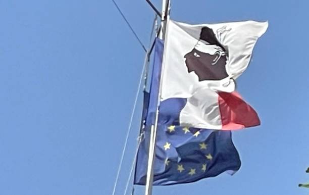 Corsican flag Flags of Corsica, France and the European Union fly over a blue sky corsican flag stock pictures, royalty-free photos & images