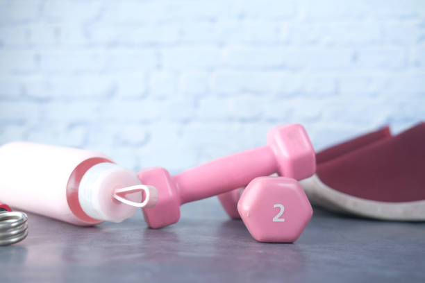 istock pink color dumbbell, exercise mat and water bottle on white background 1333673705