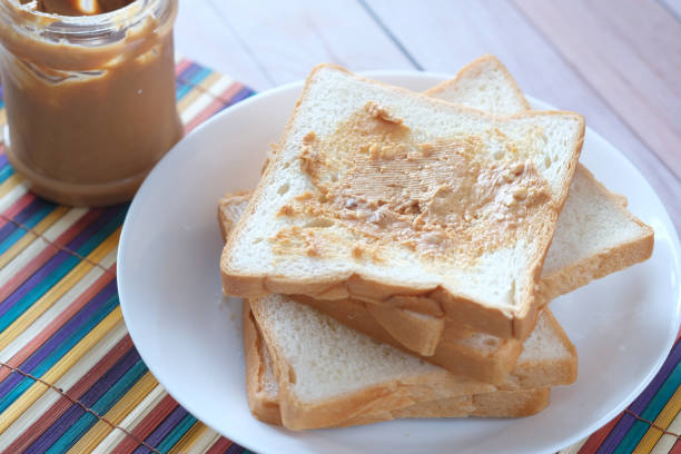top view of peanut butter and stack of bread on table