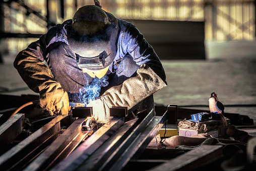 Soldadura de acero o soldador industrial en la fábrica. El daño sucederá a la salud de la inhalación de humo del soldador de la soldadura de acero. photo